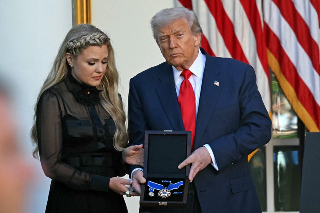 Trump memberikan medali 'Presidential Medal of Freedom' kepada Charlie Kirk. Medali ini diterima oleh istri Kirk, Erika, di Gedung Putih, Selasa (14/10).  Foto: Andrew Caballero-Reynolds/AFP