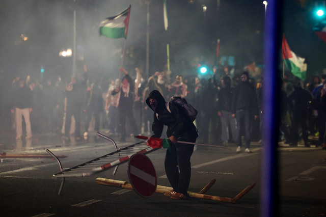Demonstran pro-Palestina yang menentang Timnas Israel terlibat bentrok dengan polisi di Udine, Italia, Selasa (14/10/2025). Foto: Yara Nardi/REUTERS
