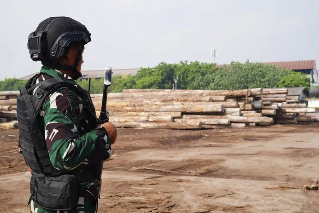 Anggota TNI berjaga di lokasi pengamanan kayu hasil illegal logging di Pelabuhan Gresik, Jawa Timur. Foto: Instagram/ @puspentni
