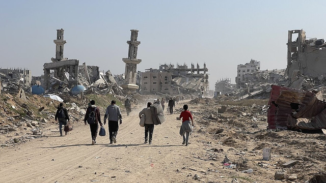 Warga Palestina berjalan di antara reruntuhan bangunan di Jalur Gaza. Sumber: https://commons.wikimedia.org/wiki/File:Forced_Displacement_of_Gaza_Strip_Residents_During_the_Gaza-Israel_War_23-25.jpg