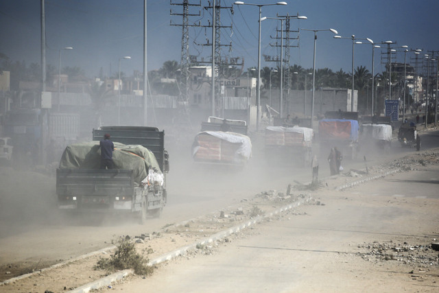 Sejumlah truk yang membawa bantuan untuk Gaza melintas di Deir el-Balah, wilayah tengah Jalur Gaza, Rabu (15/10/2025). Foto: Bashar Taleb/AFP