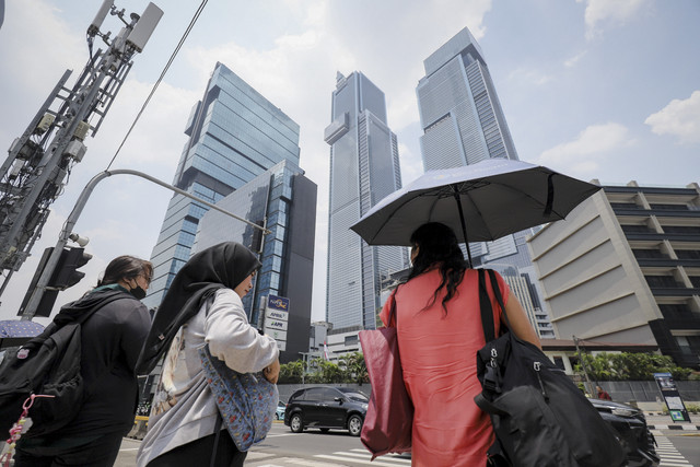 Warga menggunakan payung saat cuaca terik di kawasan Bundaran HI, Jakarta, Kamis (16/10/2025). Foto: Jamal Ramadhan/kumparan