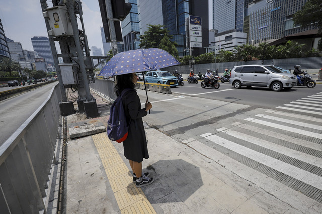 Warga menggunakan payung saat cuaca terik di kawasan Bundaran HI, Jakarta, Kamis (16/10/2025). Foto: Jamal Ramadhan/kumparan