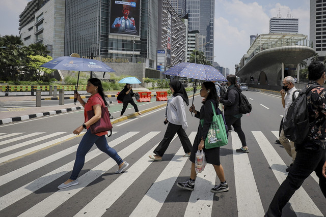 Warga menggunakan payung saat cuaca terik di kawasan Bundaran HI, Jakarta, Kamis (16/10/2025). Foto: Jamal Ramadhan/kumparan