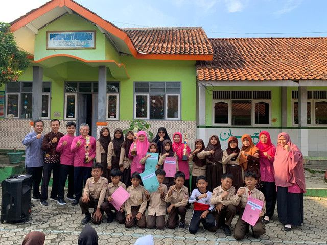 Guru dan siswa sedang foto bersama piala yang diraih