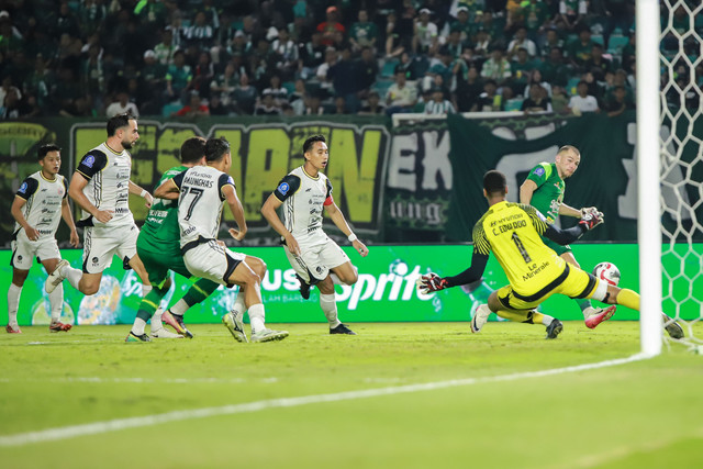 Pesepak bola Persebaya Surabaya Mihailo Perovic menendang bola yang dihadang penjaga gawang Persija Jakarta Carlos Eduardo Soares Mota pada pertandingan BRI Super League di Stadion Gelora Bung Tomo, Surabaya, Jawa Timur, Sabtu (18/10/2025). Foto: Rizal Hanafi/ANTARA FOTO
