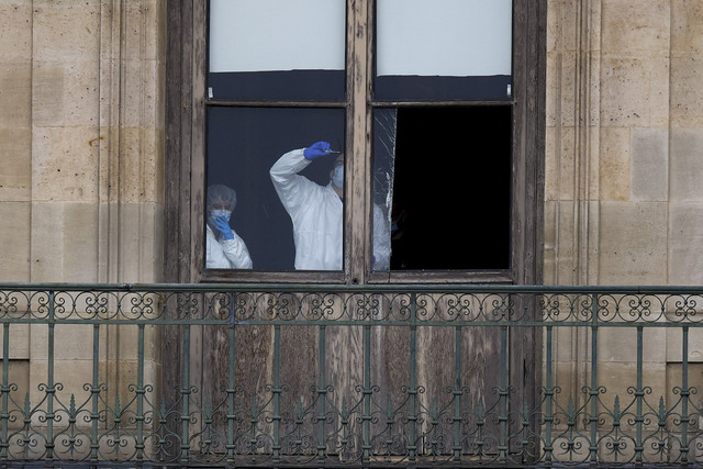 Petugas forensik kepolisian memeriksa jendela yang dibobol dalam aksi perampokan di Museum Louvre, Paris, Prancis, Minggu (19/10/2025). Foto: Gonzalo Fuentes/Reuters