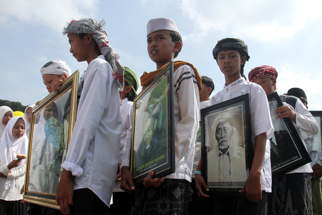 Santri membawa foto sejumlah kyai saat mengikuti gerak jalan dalam Festival 1001 Terompah di Lapangan Tumapel, Singosari, Malang, Jawa Timur, Rabu (22/10/2025). Foto: ANTARA FOTO/Ari Bowo Sucipto