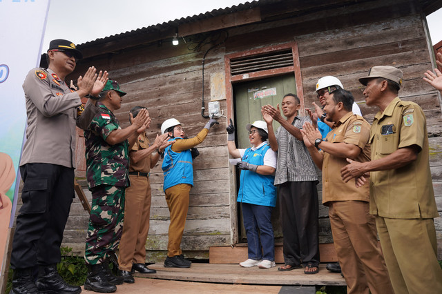 Wakil Bupati Sanggau, Susana Herpena, S. Sos, (keempat dari kiri) bersama General Manager PLN UID Kalbar, Maria G.I. Gunawan, (kelima dari kanan), bersama para Muspika, melakukan penyalaan Listrik dirumah Penerima Manfaat Dominikus Toni, (keempat dari kanan). Senyum bahagia terpancar dari wajah mereka. Foto: Dok. PLN UID Kalbar