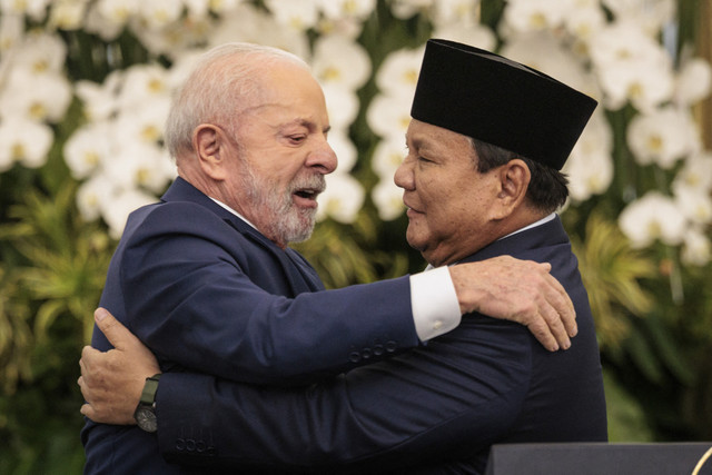 Presiden Prabowo Subianto berpelukan dengan Presiden Brasil Luiz Inacio Lula da Silva usai menyampaikan keterangan pers saat melakukan pertemuan kenegaraan di Istana Merdeka, Jakarta, Kamis (23/10/2025). Foto: Yasuyoshi Chiba/AFP