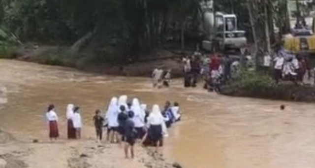 Sejumlah anak berseragam SD dan SMP menyeberangi sungai beraliran deras di Kabupaten Pandeglang. Foto: Dok. Istimewa
