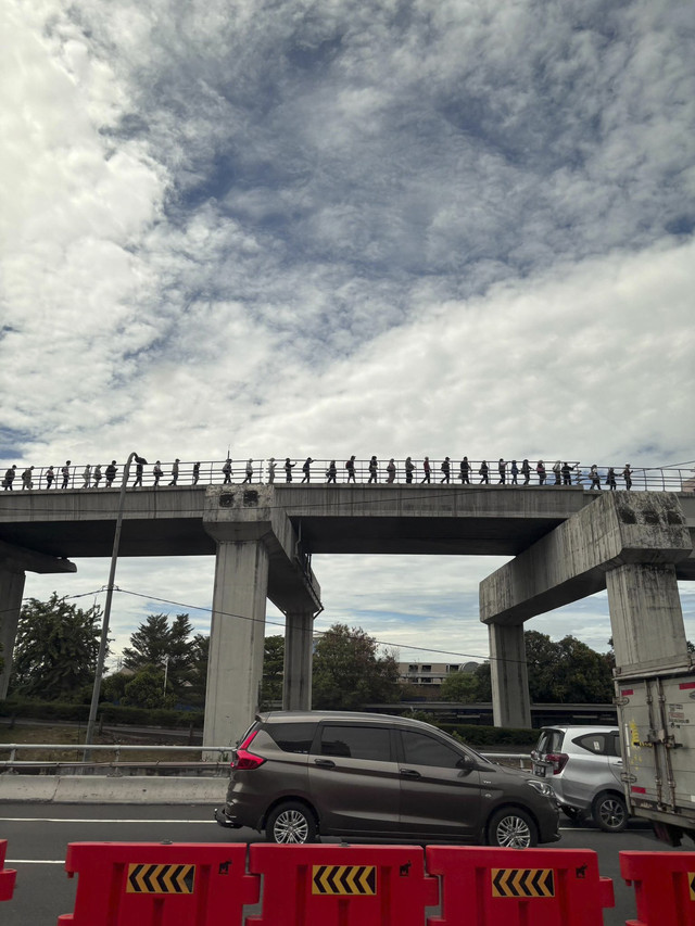 Para penumpang kereta berjalan di atas rel LRT di kawasan Cawang, Jakarta, Sabtu (25/10/2025).  Foto: Indah Tridiyanti Hutomo