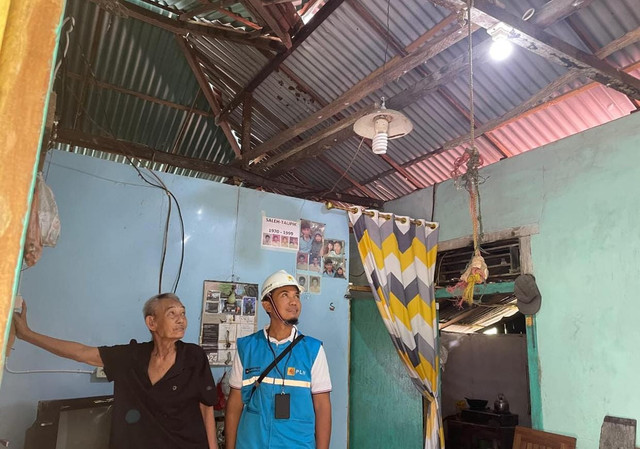 Manager PLN ULP Sei Duri, Teguh Arif Pratama Adi Putra, bersama Saleh, salah satu penerima manfaat program Light Up The Dream (LUTD), menyaksikan cahaya pertama yang kini menerangi rumah sederhana mereka. Foto: Dok. PLN UID Kalbar