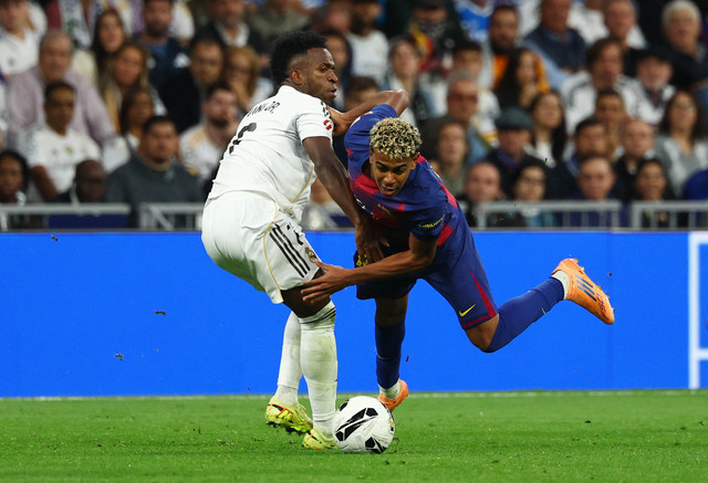 Vinicius Junior dari Real Madrid beraksi bersama Lamine Yamal dari FC Barcelona pada pertandingan Liga Spanyol antara Real Madrid v FC Barcelona di Santiago Bernabeu, Madrid, Spanyol, Minggu (26/10/2025). Foto: Susana Vera/REUTERS