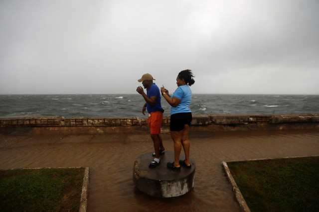 Orang-orang berdiri di sepanjang tepi laut Kingston saat Badai Melissa mendekat, di Kingston, Jamaika, Senin (27/10/2025). Foto: Octavio Jones/REUTERS