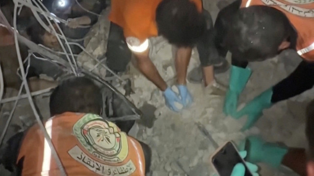 Penyelamat berupaya membebaskan orang-orang yang terjebak di reruntuhan bangunan setelah serangan Israel di Kota Gaza pada Selasa (28/10/2025). Foto: OBTAINED BY REUTERS