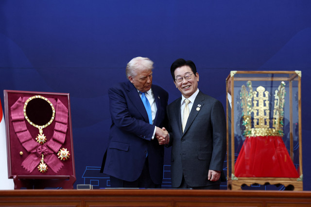 Presiden AS Donald Trump menerima "Grand Order of Mugunghwa" dan replika mahkota emas saat bertemu Presiden Korea Selatan Lee Jae-myung di sela-sela KTT para pemimpin Kerja Sama Ekonomi Asia-Pasifik di Gyeongju, Korea Selatan, Rabu (29/10/2025). Foto: Evelyn Hockstein/REUTERS