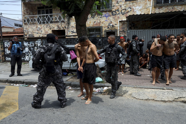 Sejumlah anggota polisi militer mengamankan pengedar narkobapada operasi melawan perdagangan narkoba di favela do Penha, Rio de Janeiro, Brasil, Selasa (28/10/2025). Foto: Aline Massuca/REUTERS