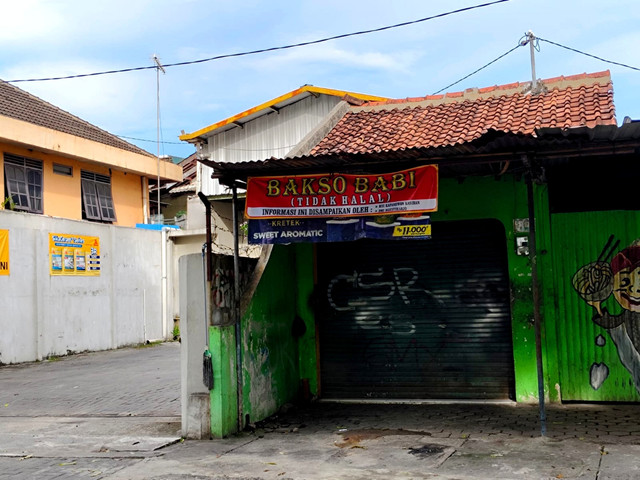 Spanduk bertuliskan bakso babi (tidak halal) berlogo Dewan Masjid Indonesia (DMI) Ngestiharjo terpampang di depan warung bakso Kapanewon Kasihan, Kabupaten Bantul, yang libur pada Rabu (29/10/2025). Foto: Arfiansyah Panji Purnandaru/kumparan