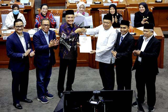 Ketua Panitia Kerja (Panja) BPIH Abdul Wachid (ketiga kanan) menyerahkan berkas hasil rapat kepada Komisi VII DPR dan Badan Pelaksana BPKH usai rapat Panja BPIH di Kompleks Parlemen, Senayan, Jakarta, Rabu (29/10/2025). Foto: Dhemas Reviyanto/ANTARA FOTO