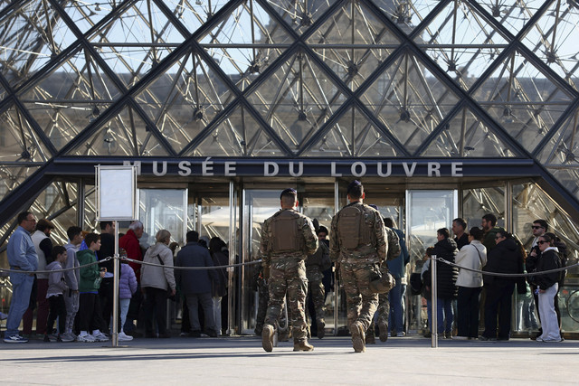 Dua tentara melakukan patroli di sekitar Piramida Kaca Museum Louvre di Paris, Prancis, Kamis (30/10/2025). Foto: Abdul Saboor/REUTERS
