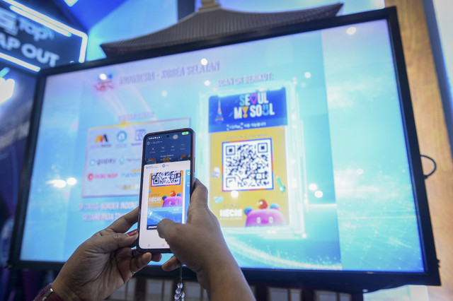 Pengunjung mencoba memindai QRIS Korea Selatan saat Festival Ekonomi dan Keuangan Digital (FEKDI) x Indonesia Fintech Summit & Expo (IFSE) 2025 di Jakarta, Kamis (30/10/2025). Foto: Putra M. Akbar/ANTARA FOTO 
