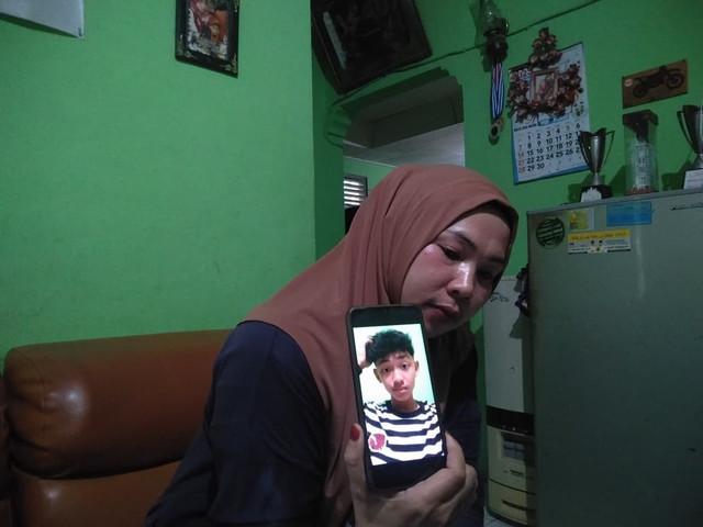 Satria Monalisa, sang ibu, menunjukkan foto Arif Nofriadi Jefri. Dok: kumparan