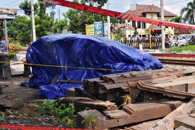 Bangkai mobil dan motor yang terlibat kecelakaan dengan kereta api ditutup terpal di Prambanan, Kabupaten Sleman, Selasa (4/11/2025). Foto: Arfiansyah Panji Purnandaru/kumparan