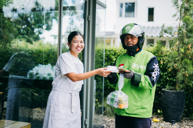 Pemilik Lunch For My Husband (LFMH), Yori Atira memberikan paket sandwich kepada mitra driver GoSend. Foto: Dok. Gojek