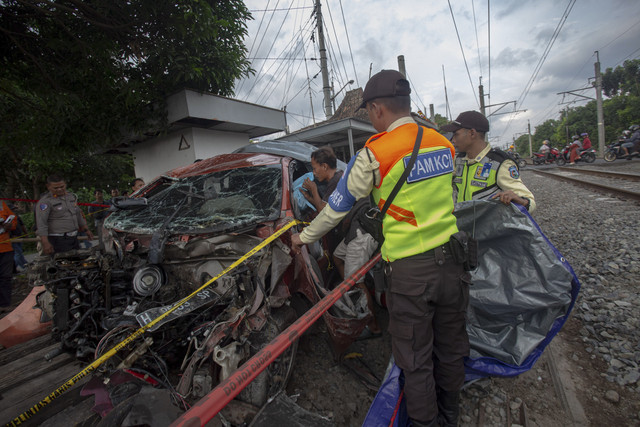 Keluarga korban mengambil barang dari mobil yang tertabrak kereta 161 Bangunkarta di perlintasan antara Stasiun Brambanan dan Maguwo, Prambanan, Sleman, D.I Yogyakarta, Selasa (4/11/2025). Foto: Andreas Fitri Atmoko/ANTARA FOTO
