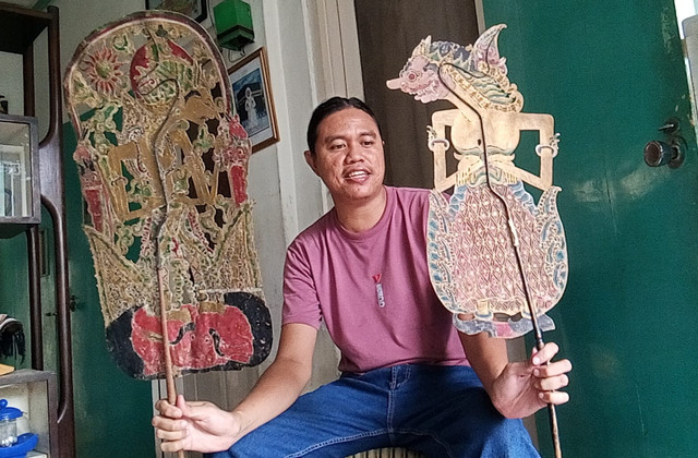 Danar menunjukkan koleksi wayang kunonya yang dibuat tahun 1932. Foto: Masruroh/Basra