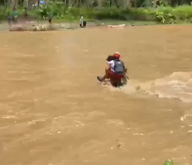 Siswa SD di Desa Bobo digendong untuk menyeberangi sungai. Dok: Istimewa