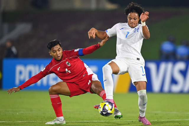 Pesepak bola Timnas Indonesia U-17 Putu Panji (kiri) berebut bola dengan pesepak bola Timnas Honduras U-17 Luis Suazo (kanan) pada laga Grup H Piala Dunia U17 2025 di Lapangan 2 Aspire Zone, Doha, Qatar, Senin (10/11/2025). Foto: Bayu Pratama S/ANTARA FOTO