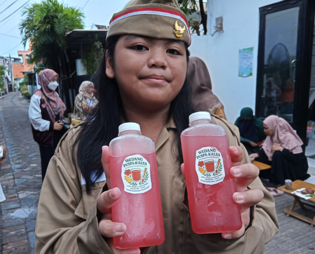 Isvara, siswi SD di Surabaya, menunjukkan minuman herbal buatannya. Minuman herbal ini diracik dari bunga pacar air. Foto: Masruroh/Basra