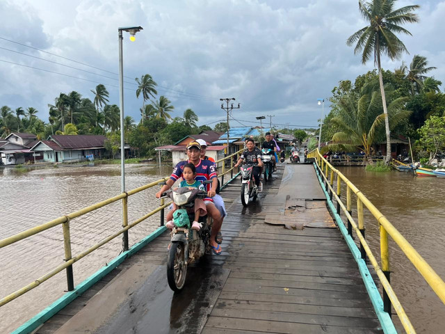 Warga Kecamatan Kubu sangat berhati-hati melintas dijembatan tersebut. Foto: Rabiansyah/Hi!Pontianak.