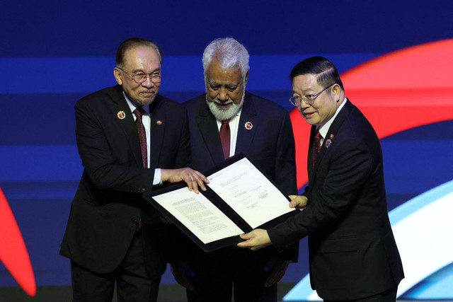 Momen bersejarah penerimaan Timor-Leste sebagai anggota ASEAN ke-11. Tampak PM Malaysia Anwar Ibrahim, PM Timor Leste Xanana Gusmao dan Sekretaris Jenderal ASEAN Kao Kim Hourn, berpose usai penandatanganan deklarasi pada KTT ASEAN ke-47 di Kuala Lumpur, 26 Oktober 2025. (Chalinee Thirasupa/REUTERS)