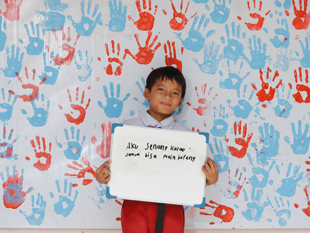 Siswa SDN Pejaten Barat 01 berpose memegang tulisan kampanye anti perundungan di halaman SDN Pejaten Barat 01, Jakarta Selatan. Foto: Jamal Ramadhan/kumparan