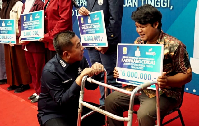 Bupati Karawang Aep Syaepuloh menyerahkan Beasiswa Karawang Cerdas (Kacer) kepada warganya. Foto: Dok. Istimewa