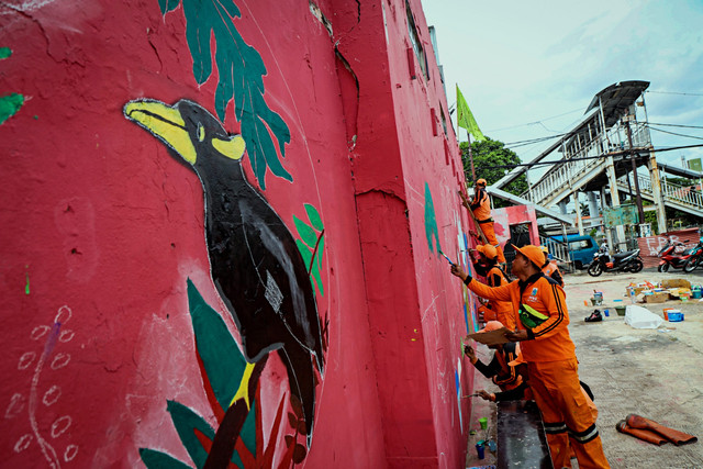 Sejumlah petugas PPSU Srengseng Sawah membuat mural di tembok sekitar kawasan Sentra Fauna dan Kuliner, Lenteng Agung, Jakarta Selatan, Jumat (14/11/2025). Foto: Iqbal Firdaus/kumparan