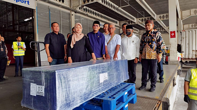 Anggota DPD RI Provinsi Sumut, Pendeta Penrad Siagian (tengah) dan Ega Prasetya, adik kandung Argo Prasetyo, warga Langkat yang tewas di Kamboja, hadiri pemulangan jenazah korban di Terminal Kargo Bandara Kualanamu, Deli Serdang, Jumat (14/11/2025). Foto: Amar Marpaung/kumparan