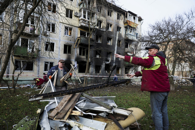 Petugas penyelamat membersihkan puing-puing yang terkena serangan drone dan rudal Rusia di salah satu gedung apartemen di Kiev, Ukraina. Foto: Thomas Peter/Reuters