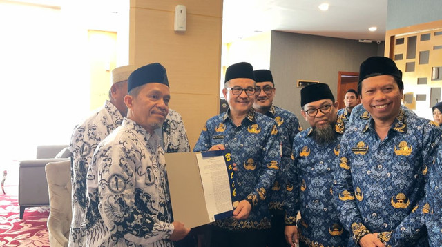 Rasnal (kiri) dan Abdul Muis menerima SK pengaktifan kembali sebagai ASN. Foto: Dok. Pemprov Sulsel