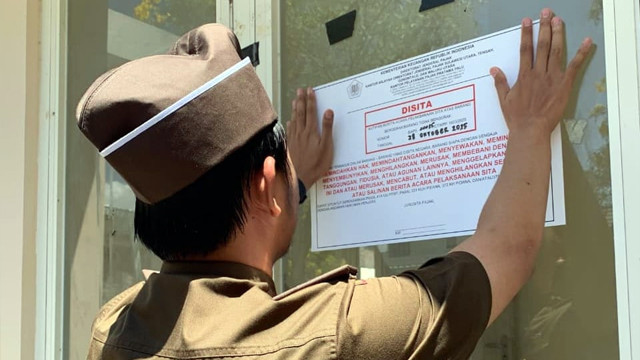 Petugas DJP Suluttenggomalut saat memasang tanda sita di aset milik wajib pajak yang menunggak pembayaran perpajakan.