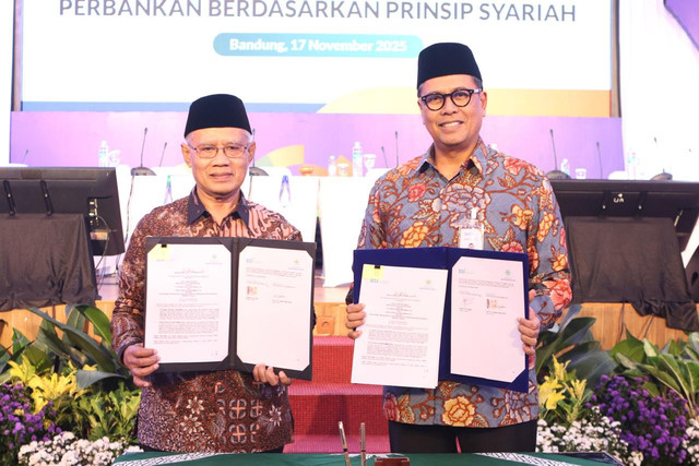 Dirut Bank BSI Anggoro Eko Cahyo (kanan) bersama Ketum PP Muhammadiyah Haedar Nashir menujukkan dokumen MoU layanan perbankan syariah antara BSI dan Pimpinan Pusat Muhammadiyah, Senin (17/11/2025). Foto: Bank BSI