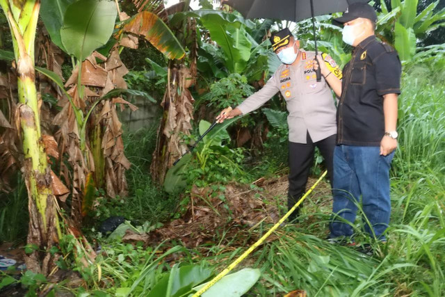 Petugas kepolisian memeriksa mayat pria yang terbungkus karung di kebun pisang, Tangerang. Foto: Dok. Istimewa