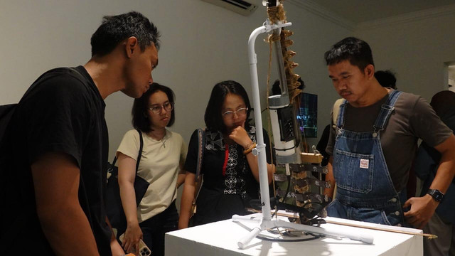Pengunjung melihat dan mendengarkan karya ‘K3Y – Kajakarta’ oleh Juan Arminandi di Galeri Nasional Indonesia. Foto: Dok. Istimewa