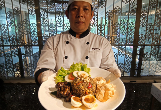 Executive Sous Chef Hotel Santika Premiere Gubeng, Muhammad Hasyim, menunjukkan nasi goreng rawon kreasinya. Foto: Masruroh/Baara