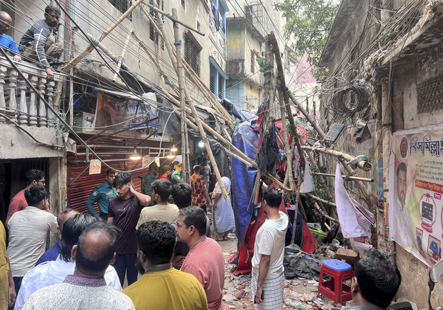 Warga berdiri di sebuah gang setelah mengungsi dari rumah mereka yang berada di samping scaffolding yang roboh akibat gempa bumi di Dhaka, Bangladesh, Jumat (21/11/2025). Foto: Mohammad Ponir Hossain/Reuters