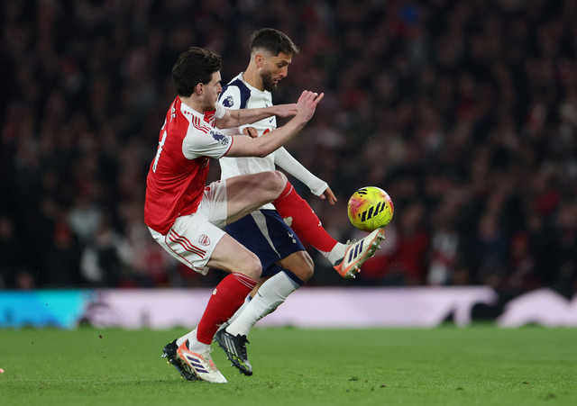 Declan Rice dari Arsenal beraksi bersama Rodrigo Bentancur dari Tottenham Hotspur pada pertandingan Liga Inggris antara Arsenal vs Tottenham Hotspur di Stadion Emirates, London, Minggu (23/11/2025). Foto: Hannah McKay/REUTERS