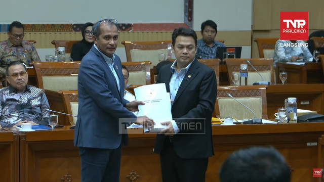 Wakil Menteri Hukum Edward Omar Sharif Hiariej (kiri) menerima draft dokumen saat mengikuti rapat kerja dengan Komisi III DPR RI di Kompleks Parlemen, Senayan, Jakarta, Senin (24/11/2025). Foto: Youtube/ TVR Parlemen